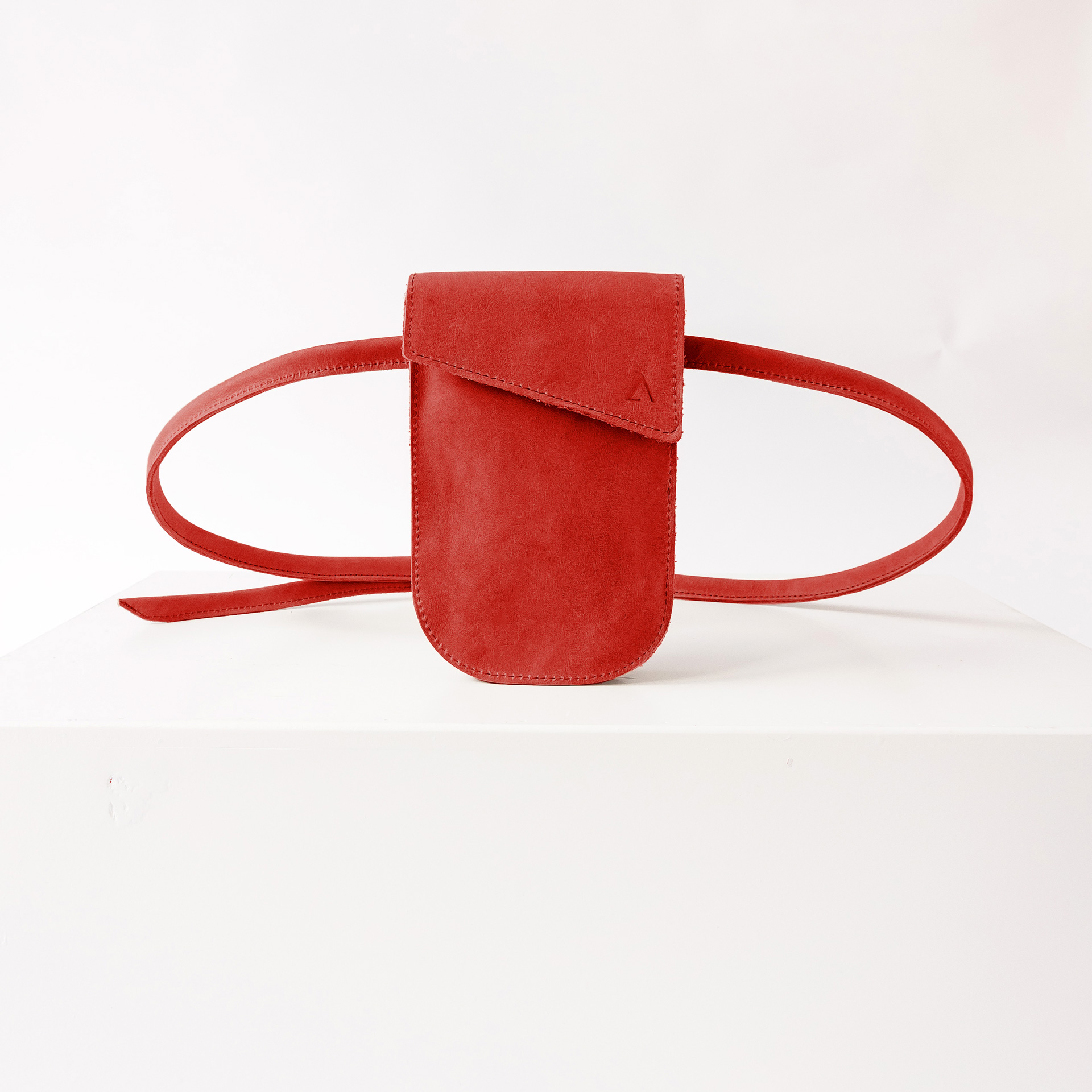 Handytasche Brustbeutel IRA aus nachhaltigem Naturleder in Rot mit dezenter Logoprägung und langem Träger