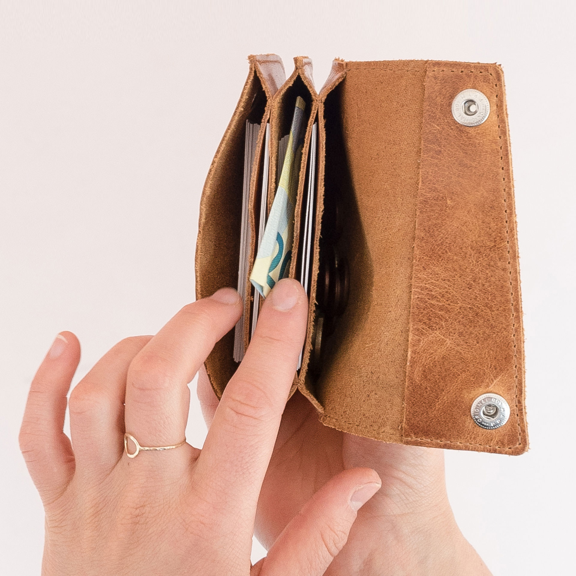 Minimalistisches Portemonnaie ENO aus Naturleder in Cognac geölt von innen gefüllt mit Karten, Geldscheinen und Münzen