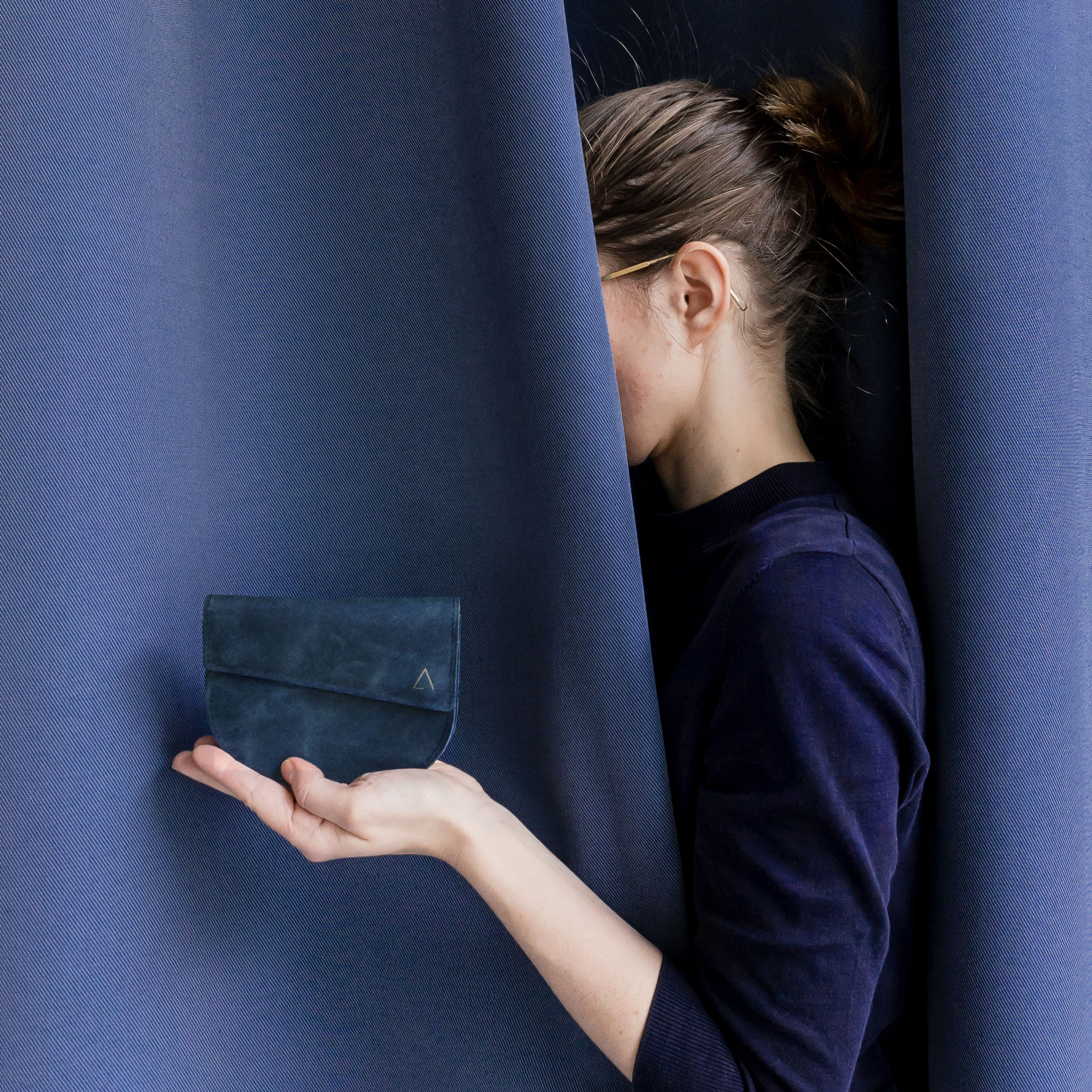 Model hält Portemonnaie UNA dunkelblau aus nachhaltigem Naturleder
