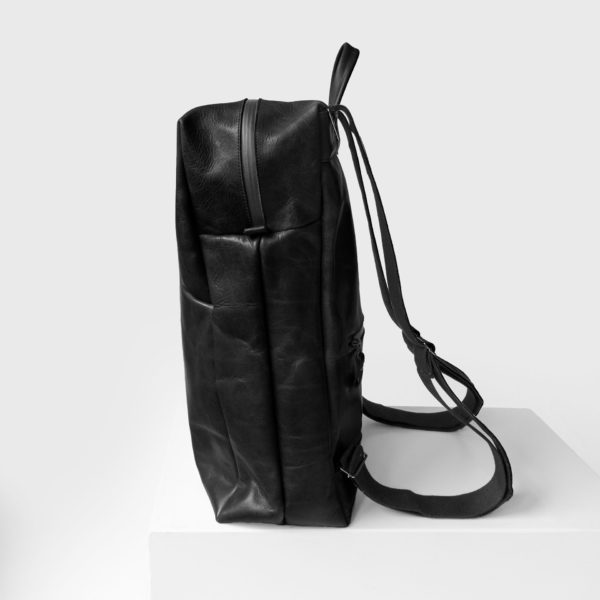 Seitenansicht des Rucksacks NEO LARGE aus Naturleder in Schwarz geölt mit Wickelfunktion