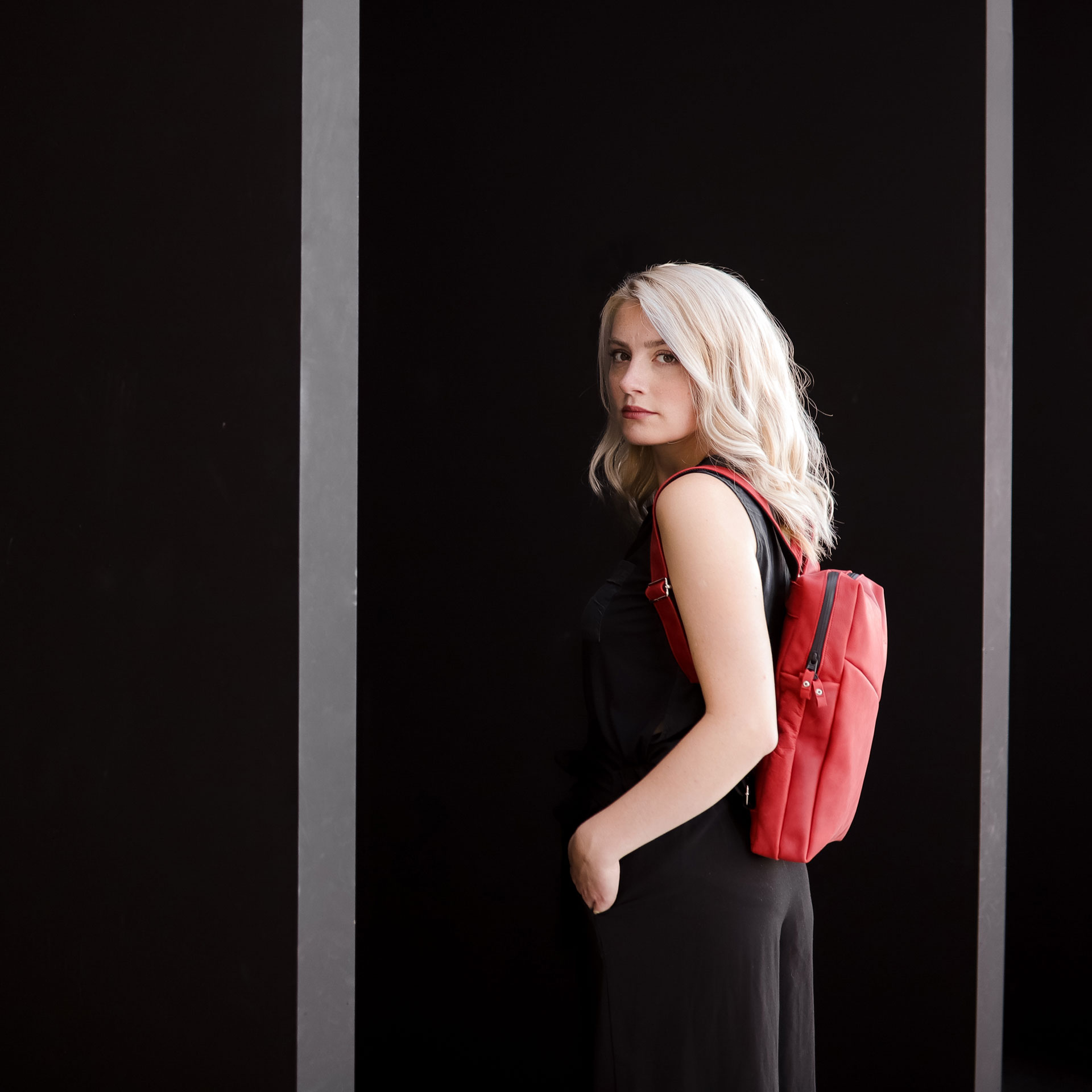 Model trägt Rucksack NEO small in der Farbe Rot.