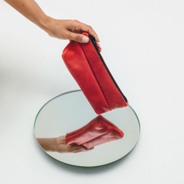 Stifteetui PEN aus nachhaltigem Naturleder in Rot über Spiegel gehalten