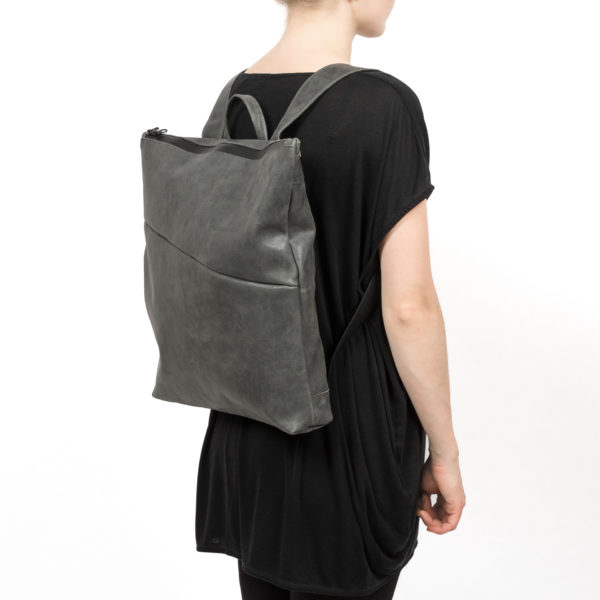 Model trägt Wickelrucksack LIN in der Farbe Steingrau