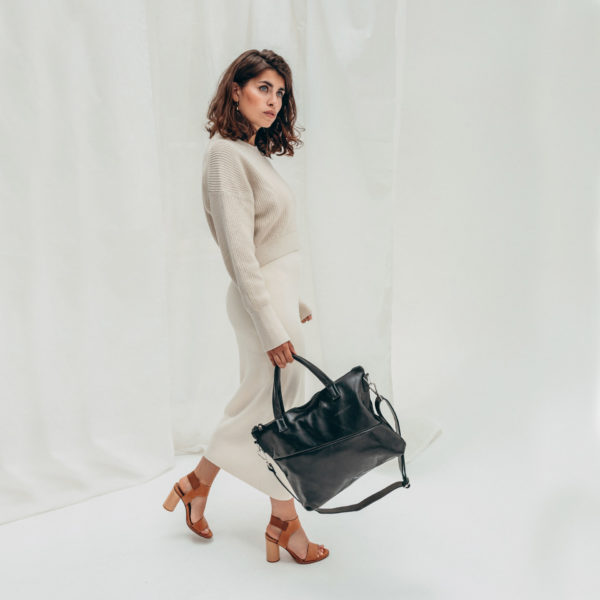 Model mit Handtasche ANA aus schwarz geöltem Naturleder mit Henkeln und Schultergurt