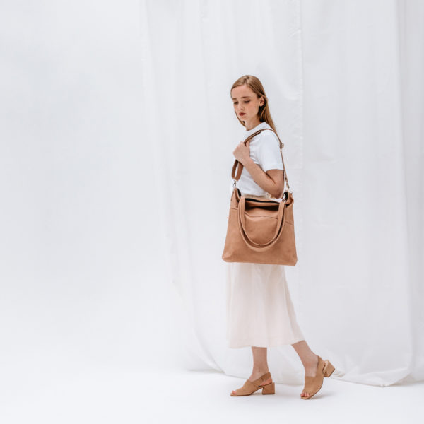 Model trägt Shopper Fia in Hellbraun aus nachhaltigem Naturleder über der Schulter.