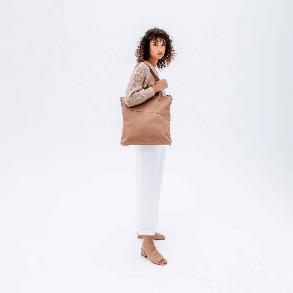 Model trägt Shopper Fia in Hellbraun aus nachhaltigem Naturleder über der Schulter.