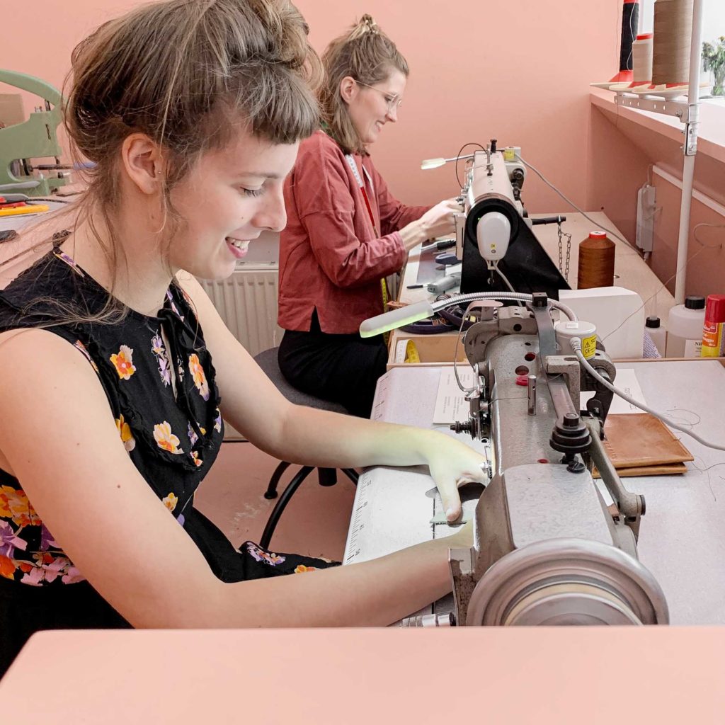 Franziska Klee und Franziska Wentz nähen an Nähmaschinen im Showroom des Ateliers