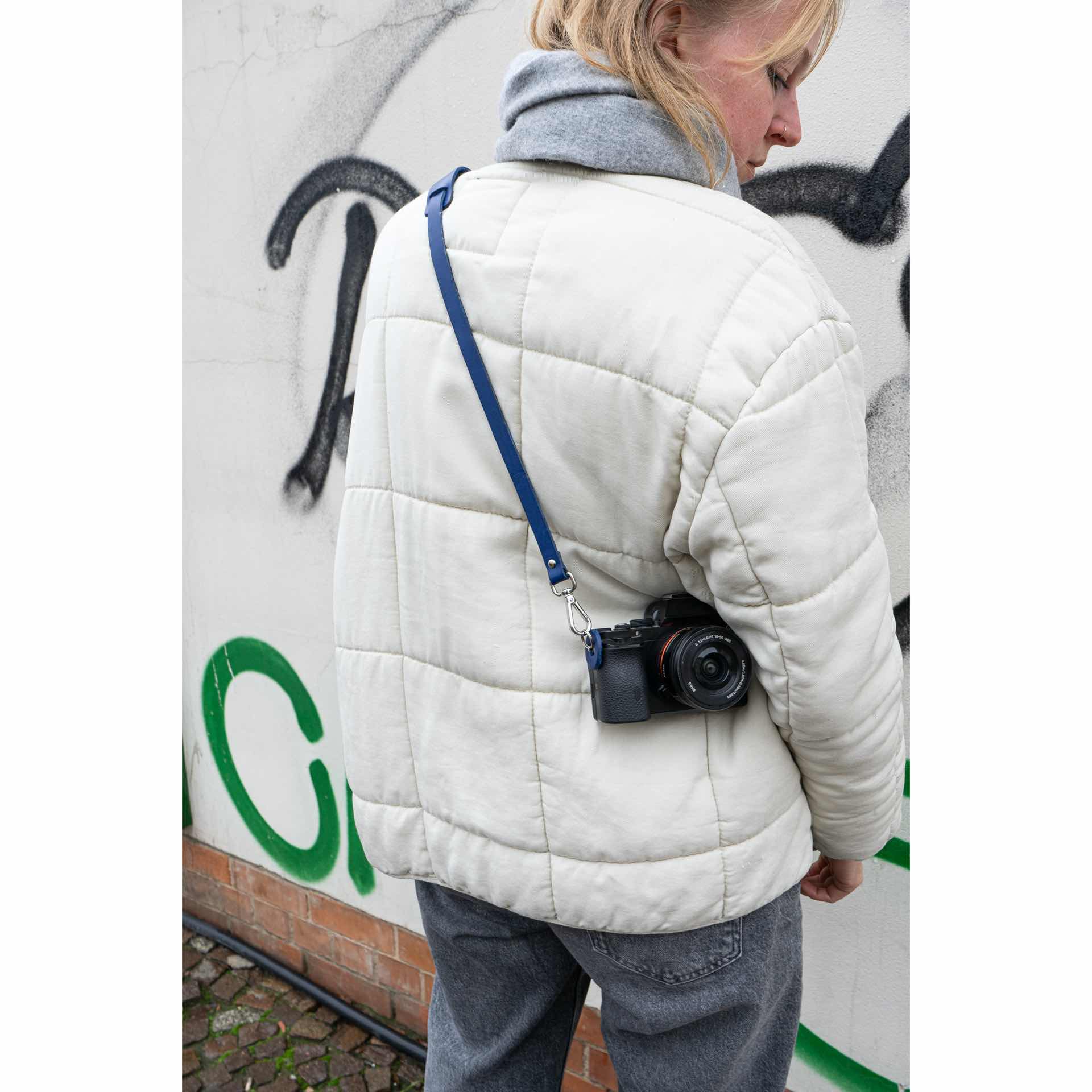 Unser Model trägt Fotogurt HAN crossbody über einer Jacke.